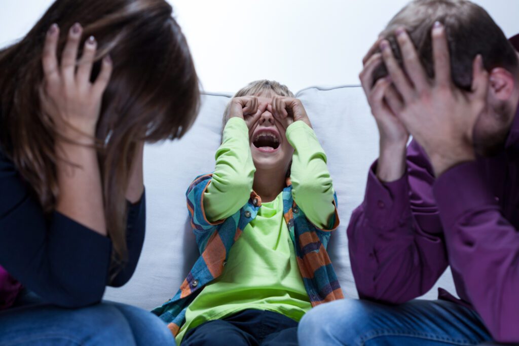View of screaming boy and tired parents