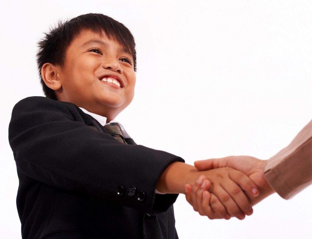 Boy In A Formal Suit Shaking Hands With Someone